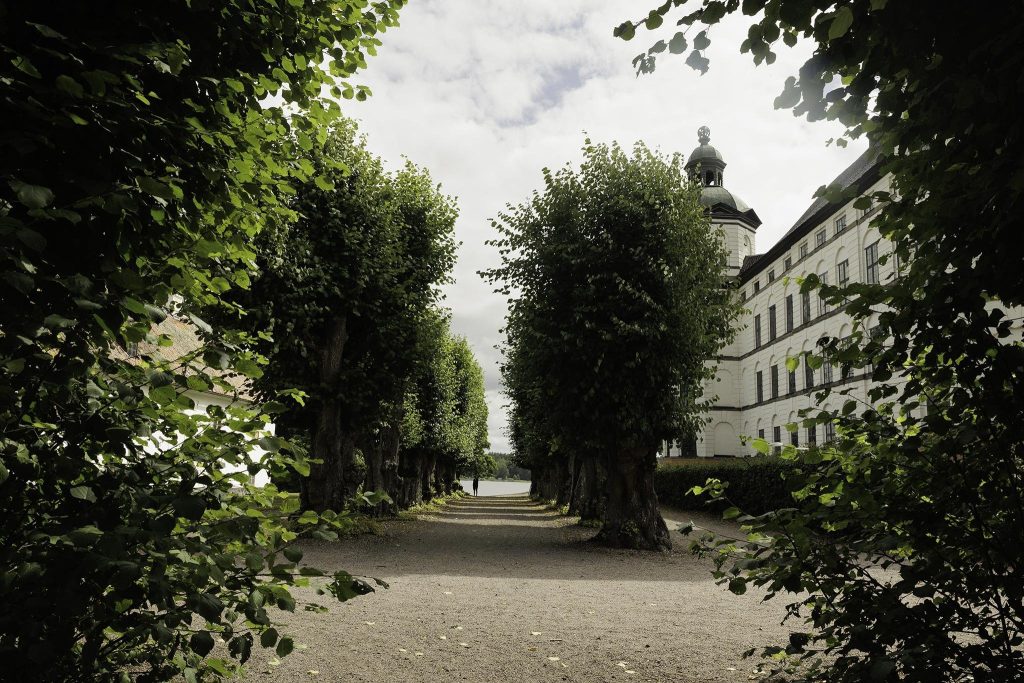 Skokloster är ett berömt slott och kloster beläget i Skoklosters socken i Uppland, Sverige. Det är ett imponerande byggnadsverk som anses vara en av de främsta exemplen på den svenska stormaktstidens arkitektur. Här är några intressanta fakta om Skokloster: Historia: Skokloster grundades på 1600-talet av den svenska greven Carl Gustaf Wrangel. Byggandet påbörjades 1654 och fortsatte under flera decennier, vilket resulterade i ett storslaget slott. Arkitektur: Skokloster slott är känd för sin imponerande arkitektur och anses vara ett mästerverk av den holländska arkitekten Nicodemus Tessin den äldre. Slottet har en tydlig holländsk renässansstil med symmetriska fasader och höga gavlar. Samlingar: Skokloster slott huserar en av Sveriges mest betydande konstsamlingar från 1600-talet. Det inkluderar värdefulla målningar, antika möbler, vapen, böcker och kuriositeter. Greve Carl Gustaf Wrangel: Greve Wrangel, en framstående militär under sin tid, var den drivande kraften bakom byggandet av Skokloster. Hans intressen sträckte sig långt bortom det militära, och han samlade på sig enastående konst och föremål från hela världen. Öppet för allmänheten: Idag är Skokloster slott öppet för allmänheten som ett museum. Besökare har möjlighet att uppleva den praktfulla interiören och den vackra omgivande trädgården. UNESCO Världsarv: Skokloster slott är en del av det gemensamma världsarvet "Kungliga domänerna runt Stockholm" tillsammans med Drottningholms slott och Ulriksdals slott. Filmlokation: På grund av dess unika arkitektur och historiska atmosfär har Skokloster även använts som en filmlokation för flera filmer och tv-serier. Det är en fascinerande plats att besöka för att få en inblick i Sveriges historia och beundra den prakt som var karakteristisk för stormaktstidens arkitektur.