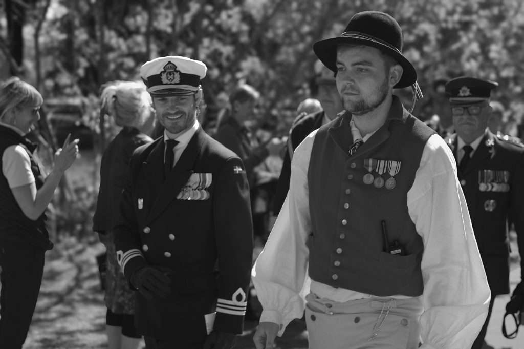 Svartvit foto av prins Carl Philip i marinuniform med medaljer, leende